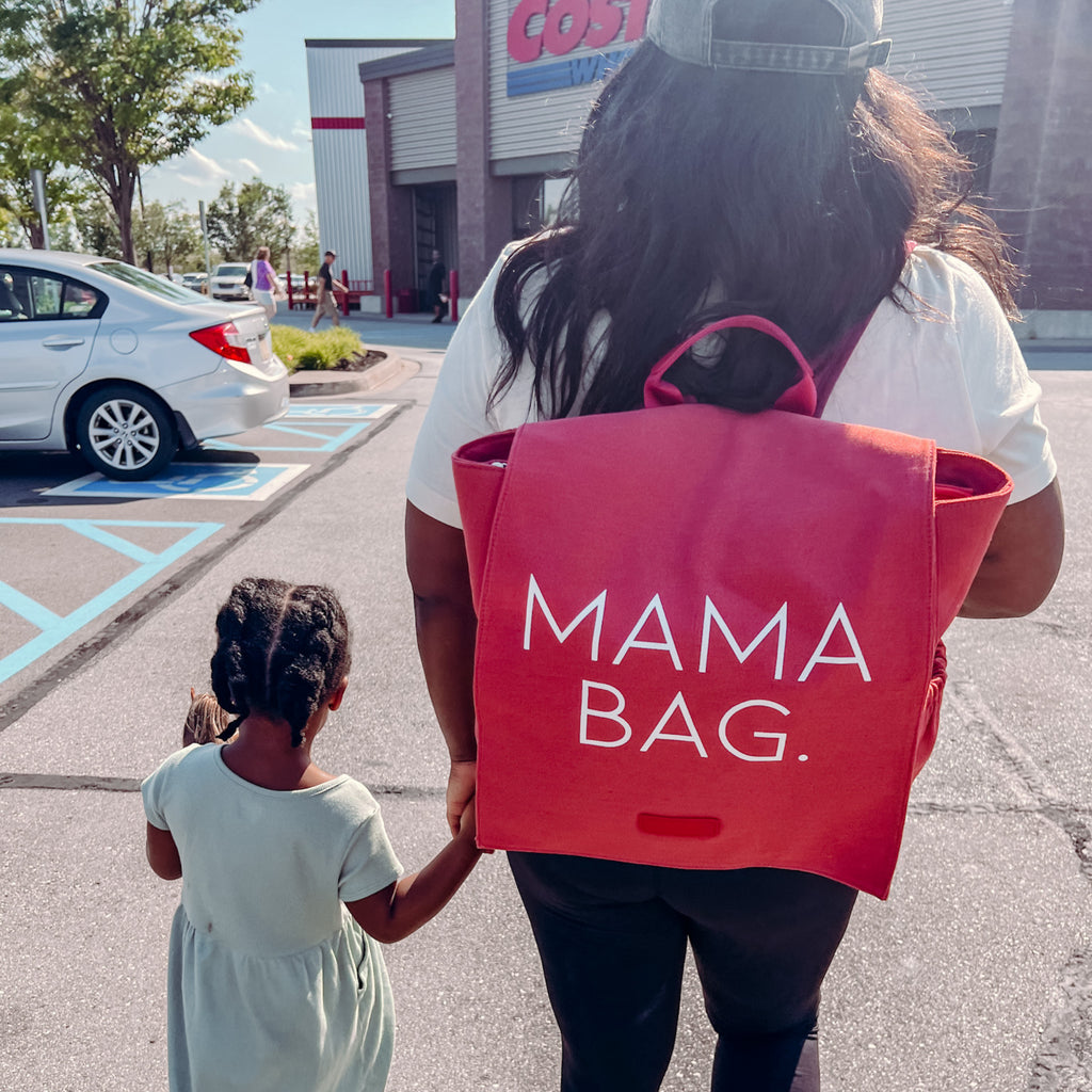 mom walking her toddler daughter to costco showcasing the kensley bag backpack in coral