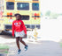 little girl in red sweatshirt with custom chenille patches, girl is in middle school and has black girl magic behind a school bus, she is in sixth grade