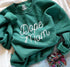 forest green crew neck sweatshirt with screen print design that says dope mom in cursive print flat lay