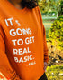 black woman, wearing pumpkin orange sweatshirt about fall with screen print text saying its going to get real basic, fall, soft pullovers