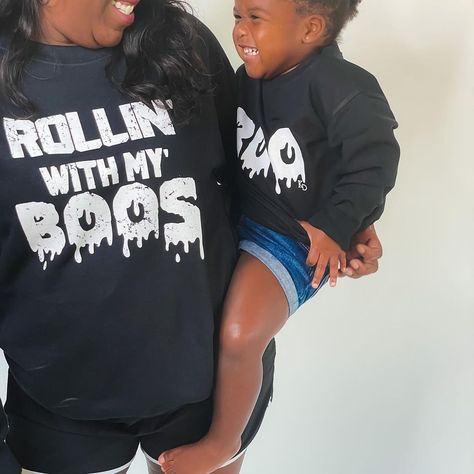 mom and toddler daughter wearing halloween sweatshirts matching and smiling in screen print designs rollin with my boos