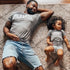girl dad shirt, dad and daughger laying on the floor posing for pops and shorty shirts in heather grey design girl dad toddler matching shirts
